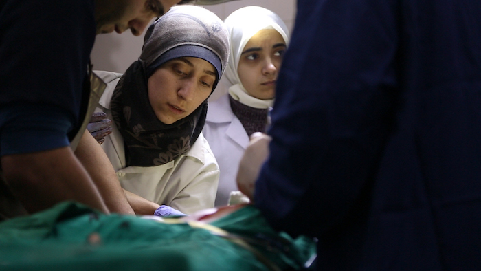 Al Ghouta, Syria - Dr. Amani (center) and Dr Alaa (right) in the operating room. (National Geographic)